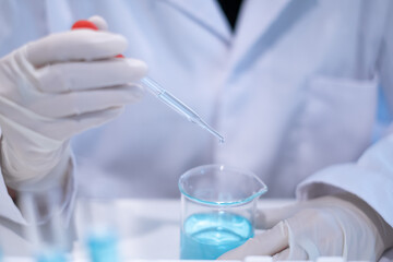 Fototapeta premium Scientist pipette doppler blue liquid in test tube beaker laboratory science biotechnology biology chemistry medical pharmaceutical DNA medical healthcare research discovery innovation experiment
