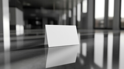 blank white name card is elegantly placed on reflective glass surface, showcasing modern and minimalistic design in contemporary setting. soft lighting enhances cards simplicity and sophistication