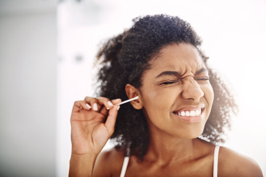 Scared, woman and cotton bud for hygiene with eyes closed for self care and cleaning. African person, home and removing earwax for germs, dirt and bacteria for wellness, routine and grooming