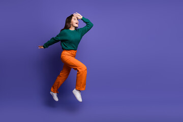 Full length portrait of nice young girl jump run empty space ad isolated on violet color background