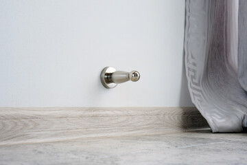 Close-up a stainless steel door stopper in a house or office.