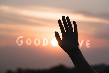 A silhouetted hand waves goodbye against a vibrant sunset, capturing a poignant moment of farewell and transition.