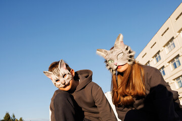 girl and boy in cat masks doing Quadrobics in the city, animal behavior simulation, Quadrobics sport