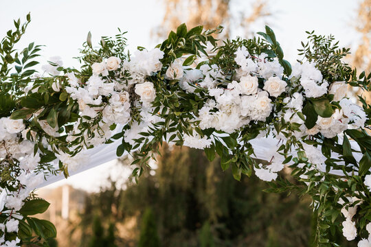 Elegant Floral Wedding Arch Adorned with White Roses and Greenery