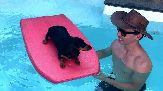 homem na piscina com cachorro salsicha em prancha de surfe