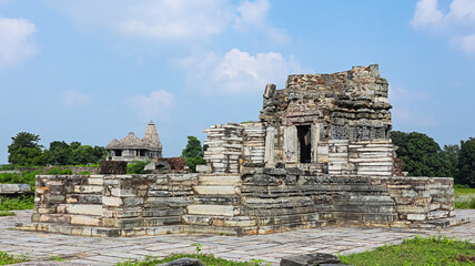 Fototapeta premium Ruined view of Chaunsath Yogini Temple with the Shiva Temple in the background, Arthuna Group of Temples, Banswara, Rajasthan, India.