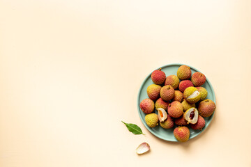 Juicy lychee fruit with cut in half and green leaves, top view. Fresh ripe tropical fruit