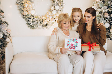 Three Generations Celebrating Christmas With Gifts at Home