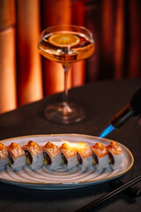 Close-up of a chef carefully searing a nigiri sushi with a culinary blowtorch.