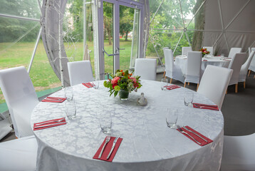 Inside of city cafe. Modern Cafe restaurant interior with white chairs around a round coffee table. Luxury restaurant interior. Empty tables at a restaurant. Modern white coffee shop interior.