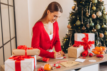 Woman Writing Holiday Cards at Gift Wrapping Station