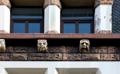 rostros grotescos en el muro de piedra