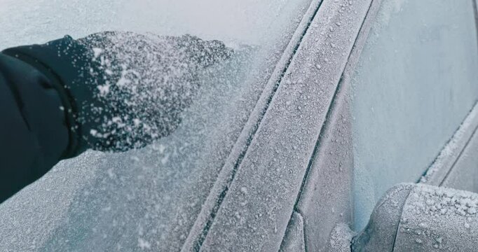 Winter Driving - An unrecognizable person is trying to remove the ice off a frozen windshield, but fails - Slow-mo 