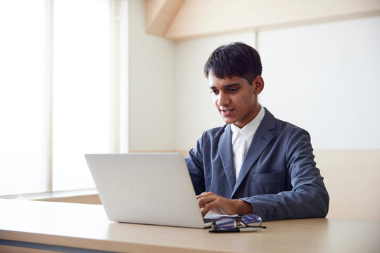 パソコンを使用して仕事をする若いインド人の技能実習生