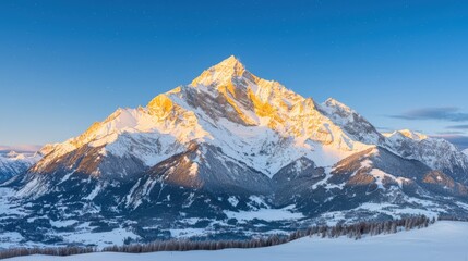 Obraz premium Majestic snow-capped mountain peaks under clear blue sky at sunrise a breathtaking winter landscape