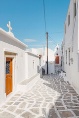 Explore the historic alleys of Hydra, where whitewashed houses and cobblestone paths create a captivating atmosphere under the clear blue sky, reflecting the island's charm.