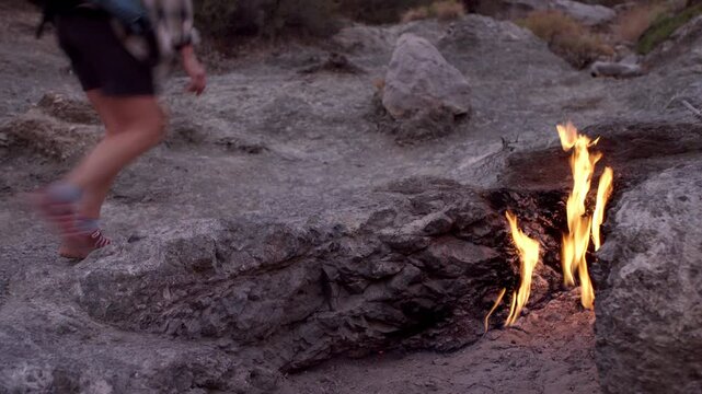 4K footage Backpacker woman hiking alone along fires of Yanartas at night on Mount Chimaera on popular hiking Lycian Way (Likya Yolu) in Antalya Province, Turkey. Unique Geothermal phenomenon.