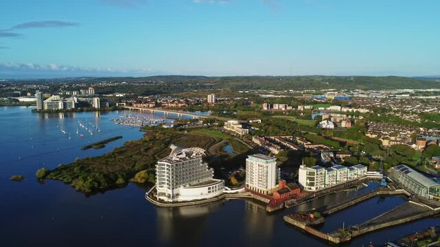 Aerial drone footage of Cardiff Bay area at sunrise, overloooking Grangetown neighbourhood. High altitude left-to-right panning shot.