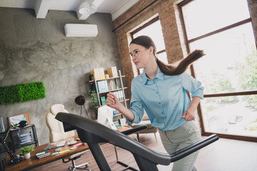 Photo of excited positive lady recruiter dressed shirt running treadmill indoors workplace...