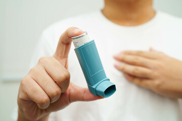 Asthma and chronic obstructive pulmonary disease COPD, Asian young man using metered dose inhaler...