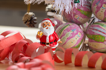 A small figurine of Santa Claus in a red and white suit holding a green sack,