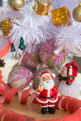 A small figurine of Santa Claus in a red and white suit holding a green sack,