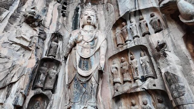 Luoyang Longmen, China: Dramatic footage of the famous ancient Buddhist statues in the Longmen grottes Fengxian main cave in Central China. Shot with a tilt up motion. 