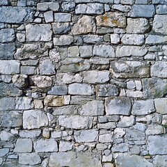 Obraz premium Textured stone wall with irregular rock arrangement, showcasing varied shades of gray and natural patterns.