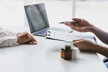 Fototapeta premium Doctor explaining diagnosis to patient and notes. Doctor and female patient discussing in examination room at hospital. Medicine and healthcare concepts.