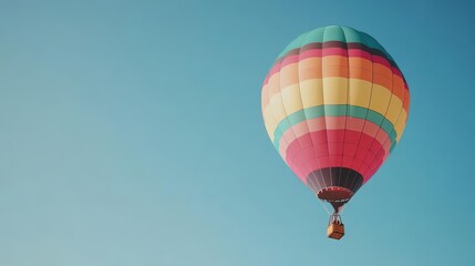 Fototapeta premium A colorful hot air balloon on a clear sky blue background