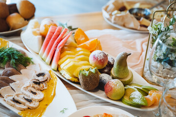 On the table, there is an assortment of colorful fruits and fresh vegetables arranged on various...