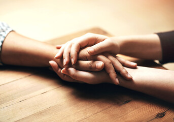 Holding hands, cancer and support of friends, care and empathy together on table in home mockup....