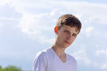 A young man with brown hair and a white shirt