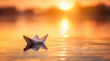 A small paper boat floating on calm, mirror-like water at sunrise