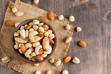 Healthy mix nuts on wooden background. Almonds, hazelnuts, cashews, peanuts, pistachios, Brazil nuts