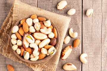 Healthy mix nuts on wooden background. Almonds, hazelnuts, cashews, peanuts, pistachios, Brazil nuts