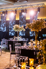 Elegant Wedding Reception with Dramatic Lighting and Floral Centerpiece - Luxurious Event Ambiance