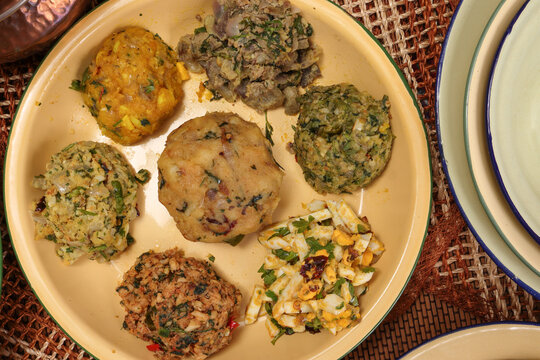 Bengali style spread verity vorta mashed bhorta potato egg brinjal shrimp prawn fish chicken liver on rustic metal tin plate
