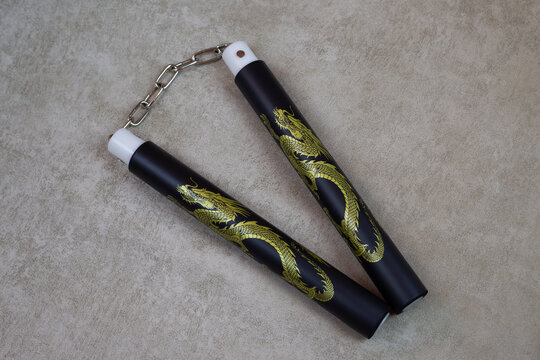 Black nunchucks with golden dragon for martial arts training, special ancient weapons for self defense. Body agility training with soft material nunchuck, martial arts culture using weapons