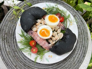 Crab, mantis shrimp and soft boiled with egg black charcoal bagel