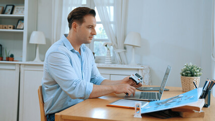 Car design engineer working on car prototype for automobile business at home office. Automotive engineering designer carefully analyze, finding flaws and improvement for car design. Synchronos