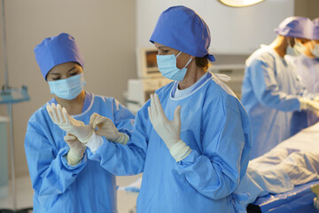 A group of surgeons are working in a hospital operating room. Scene is serious and focused, as the surgeons are performing a delicate procedure.