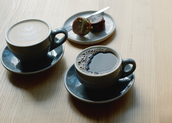 Two coffees and a sweet treat on the table.