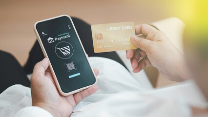 close up woman using her smartphone and her credit card at home. Online shopping, paying online, using banking service, entering information, shopping, ordering in internet store, secure payment.