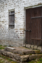 Old locked wooden door and window in vintage wall, vertical picture