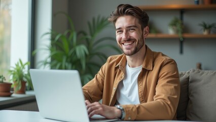 Fototapeta premium Smiling Young Man on a Video Call in a Modern Apartment with Plants