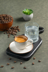Double Espresso with Water and Coffee Beans: A ceramic cup of double espresso served on a wooden board with a glass of water. Coffee beans are scattered around, adding a warm, inviting atmosphere.