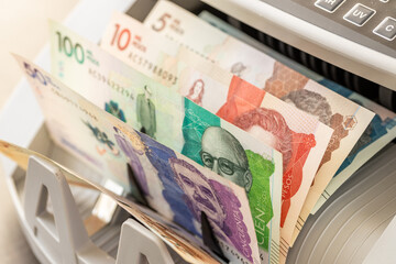 Colombian pesos counted in cash counting machine. Finance business concept. Colombia money, close up