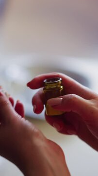Female person opens and shakes small glass bottle of soporific powder planning poison and rob lover at dinner at home closeup slow motion