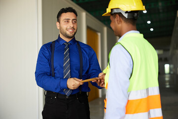 boss or manager giving money to worker for jobs in the factory